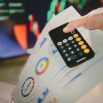 a person holding a calculator over a piece of paper