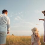 man in white dress shirt and woman in brown dress standing on green grass field during